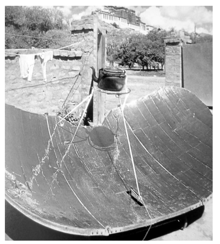 A parabolic mirror uses the sun's rays to boil a kettle of water in Tibet.